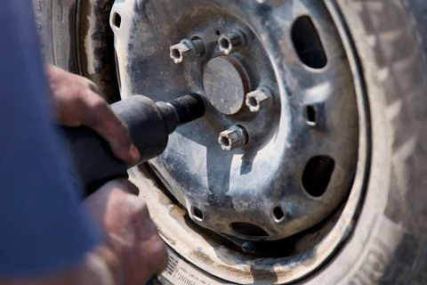 Mechanic Using Power Tool to Remove Tire Lug Nuts Stock Photos