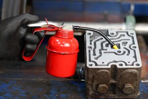 Mechanic using a pump oiler on a transmission component. Stock Photos