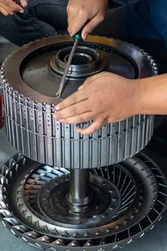 Mechanic Using Screwdriver on Automatic Transmission Clutch Assembly. Stock Photos