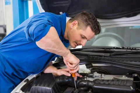 Mechanic using screwdriver on engine Stock Photos