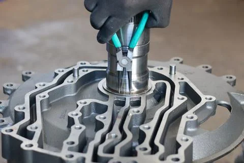 Mechanic using snap ring pliers on a transmission front support. Stock-Fotos