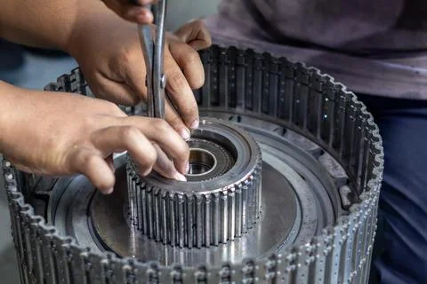 Mechanic using snap ring pliers to assemble transmission clutch pack in wor.. Stock Photos