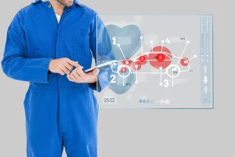Mechanic using a tablet close to an interface Stock Photos