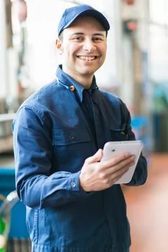 Mechanic using a tablet in his garage Stockfoto's