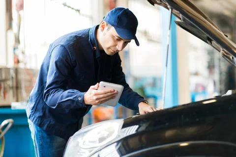 Mechanic using a tablet in his garage Foto stock