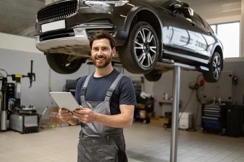 Mechanic using tablet in modern car repair shop 스톡 사진