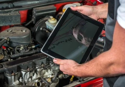 Mechanic using a tablet pc at the repair garage Foto stock