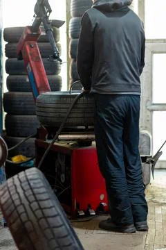 Mechanic using tire changing machine in auto repair shop Stock Photos
