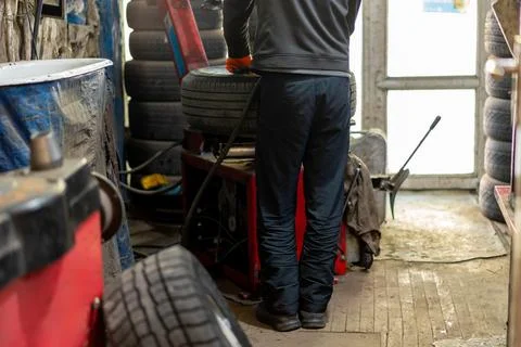 Mechanic using tire changing machine in auto repair shop Stock Photos