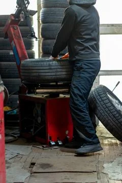 Mechanic using tire changing machine in auto repair shop Stock Photos