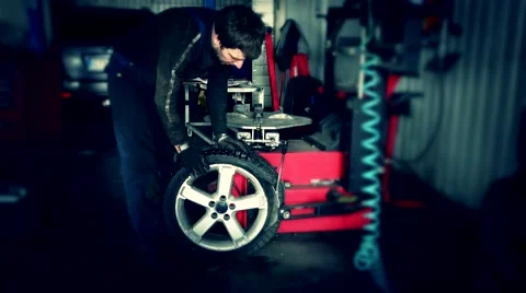 Mechanic using tire mounting tool machine Stock Footage 67435120