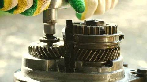 Mechanic using tool to disassemble manual transmission gears Stock-Footage 317906487