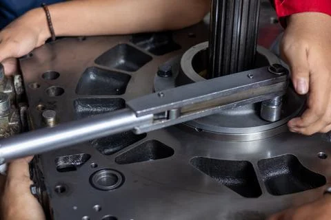 Mechanic Using Torque Wrench To Tighten Heavy Industrial Transmission Housi.. Stock Photos