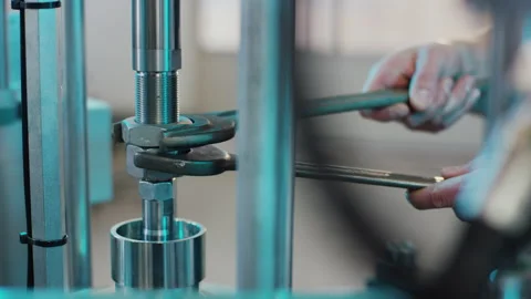 Mechanic using two wrenches to tighten nuts on industrial metal machine Video stock 155208715