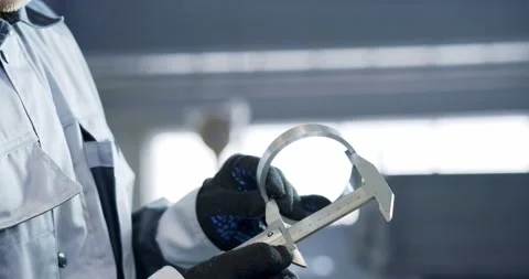 A mechanic using a vernier caliper to measure a piston rod or engine part. Stock Footage 150291102