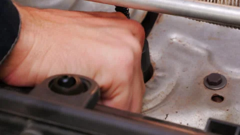 Mechanic utilizing a specialized tool to tighten a bolt beneath a vehicle seat, Stock Footage 283682621