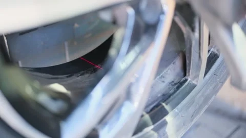 A mechanic warms up a car wheel using a hair dryer then glues on a weight Stock Footage 306882543