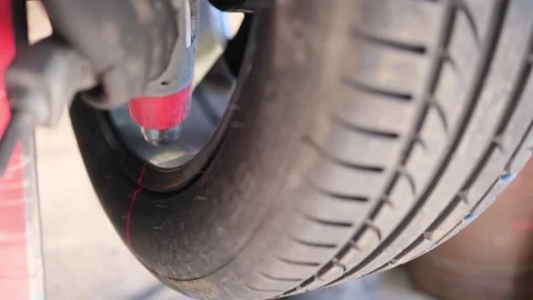 A mechanic warms up a car wheel using a hair dryer Stock Footage 306882717