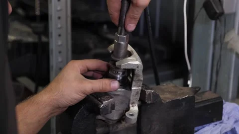 The mechanic, we fasten the nut to the part from the machine on the vise. Stock Footage 338996167