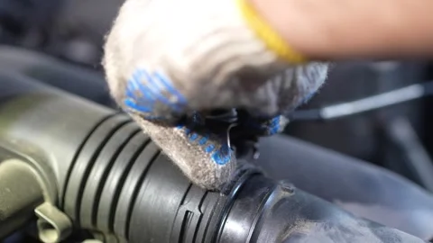 Mechanic in work gloves connects a plastic air intake pipe. Stock Footage 345709179