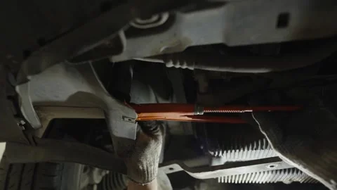 A mechanic in work gloves uses a orange pipe wrench Stock Footage 340154331