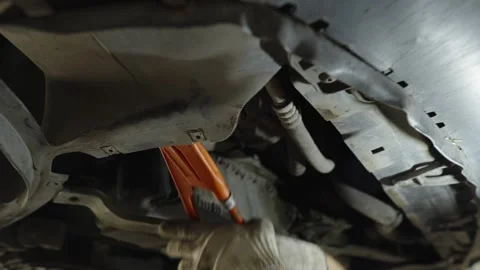 A mechanic in work gloves uses a orange pipe wrench Stock Footage 340154341