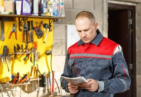 Mechanic worker studying his instructions Stock Photos