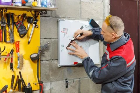 Mechanic worker studying his instructions Stock Photos