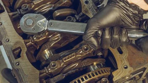 A mechanic working on a car engine in a well-equipped auto repair shop. Car.. Stock Photos