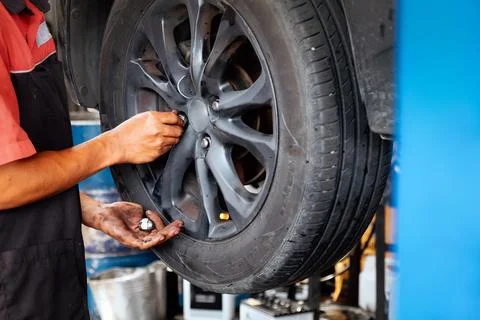Mechanic working on a car wheel Stock Photos