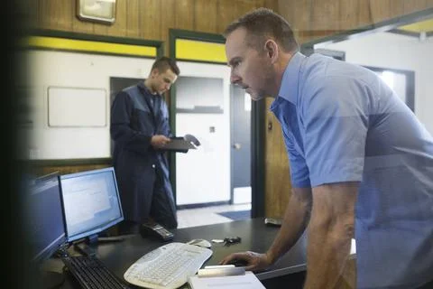Mechanic working at computer auto shop office Stock Photos
