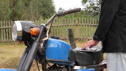 Mechanic working on laptop resting on motorcycle seat Stock Footage 314952131