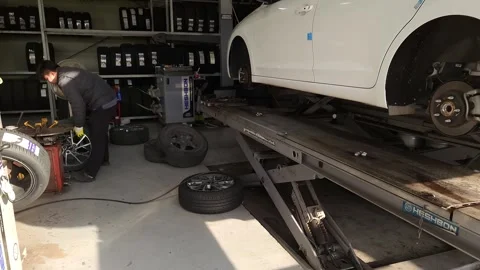  A mechanic working to replace a car tire wheel Stockbeeldmateriaal 255825259