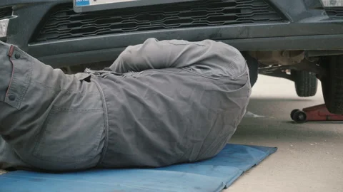 Mechanic working under a car Stock Footage 86411939