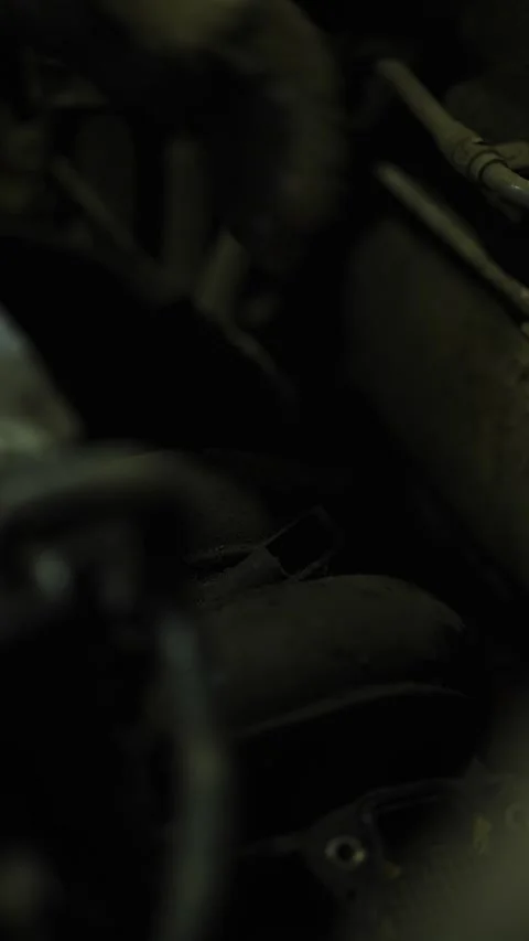 A mechanic works on dark car engine bay parts close-up. Stock Footage 338364926