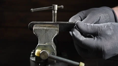 Mechanic in a workshop using a vice tightens the nut with wrenches, close up Stock Footage 299805578
