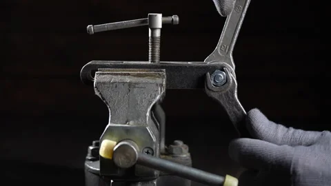 Mechanic in a workshop using a vice unscrews a nut with wrenches, close up Stock Footage 299451019