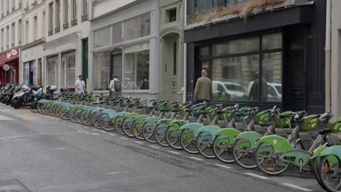 Mechanical and electric sharing bicycles stand parked at an urban street dock 動画素材 336722256