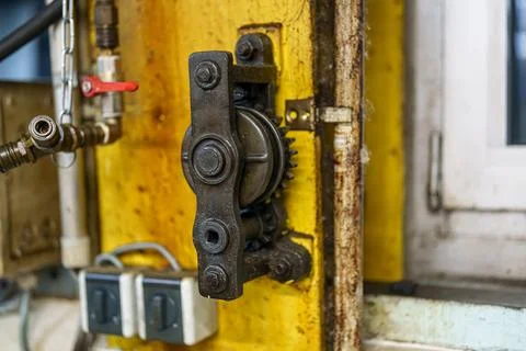 Mechanical device mounted on a yellow wall near a window in a workshop show.. Stock Photos
