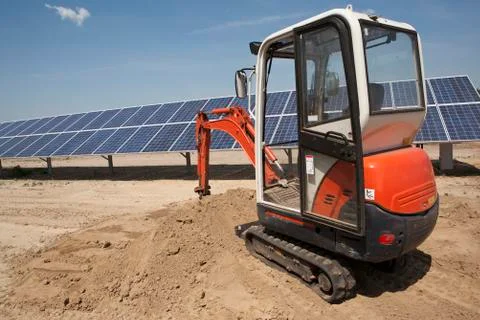 Mechanical digger on solar panel construction site Stock Photos