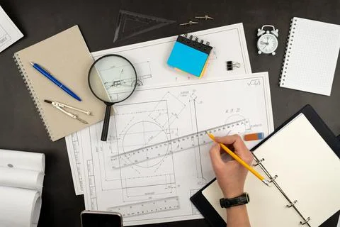 Mechanical drawing on sheets of paper. Hands on the table top view. Workflow  스톡 사진