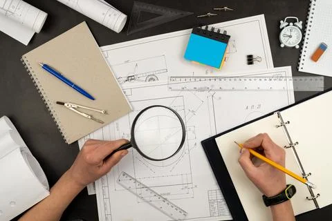 Mechanical drawing on sheets of paper. Hands on the table top view. Workflow of Foto stock