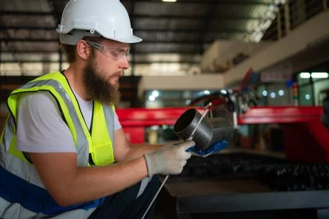 A mechanical engineer measuring product dimensions of new machinery instal... Foto stock