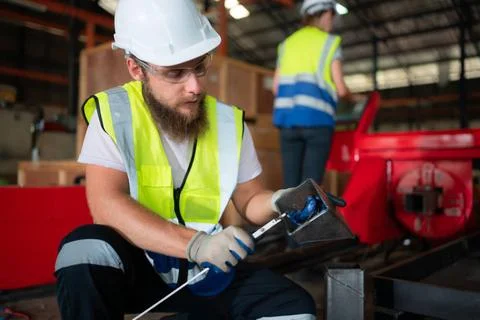 A mechanical engineer measuring product dimensions of new machinery instal... Foto stock