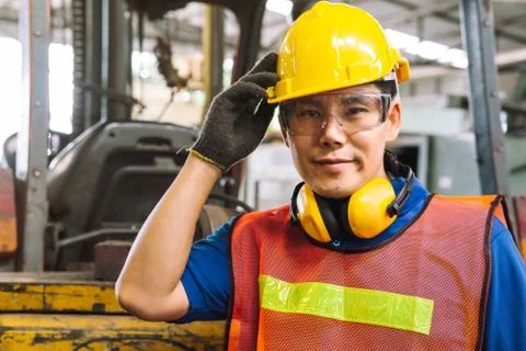 Mechanical engineer or employee worker with yellow safety helmet in a factory. Stock Photos