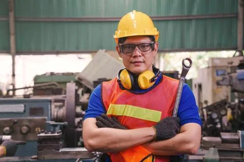 A mechanical engineer or worker holding the ring spanner at work in a factory. Stock Photos