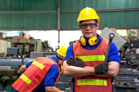 A mechanical engineer or worker holding the ring spanner at work in a factory. Stock Photos