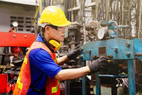 A mechanical engineer or worker   at work on production in a factory. Stock Photos