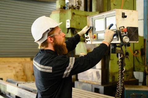 Mechanical engineer repairing engine machine at factory Stock Photos