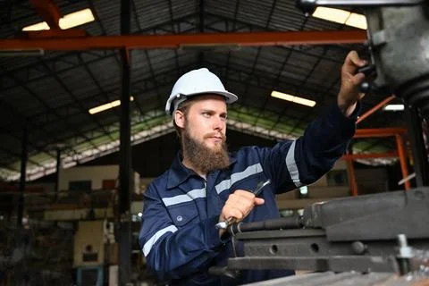Mechanical engineer repairing engine machine at factory Foto stock